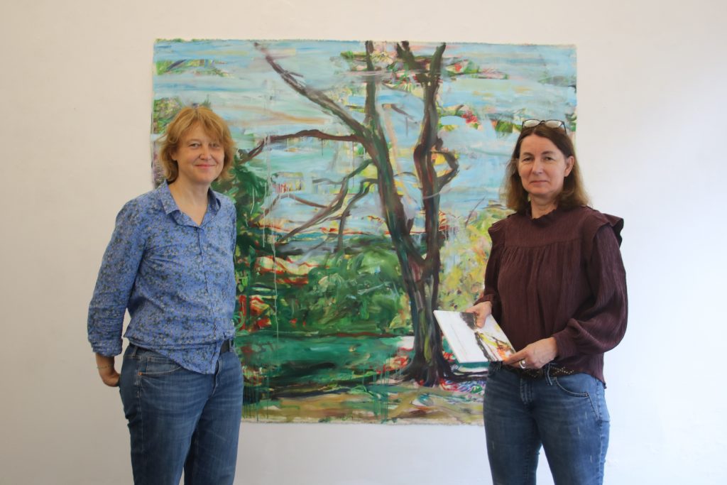 Galeristin Stefanie Gansera-Söffing (rechts) und Künstlerin Julia Roppel vor ihrem Gemälde „Maunzenweiher“ Foto: Edda Rössler