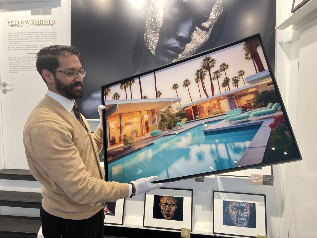 Galerieleiter Levin Wilson mit dem Werk „Pool“ des französischen Fotografen Alexandre Fauve. Neben dem Studium der Fotografie war die Inspirationsquelle die Großmutter, die als Schneiderin seinen Geschmack für Mode und Design schärfte. Wilde Tiere und Luxusvillen zählen zu seinen Motiven, oft kombiniert mit einer Prise Humor. Foto: Edda Rössler