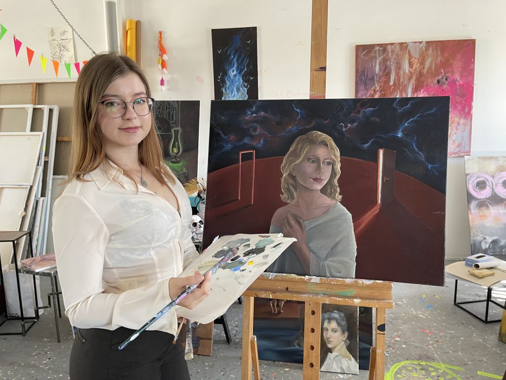 Düstere Eleganz im Atelier: Alexandra Gorev arbeitet an einem Ölbild, in dem strenge Komposition und geheimnisvolle Atmosphäre ineinandergreifen. Foto: Edda Rössler