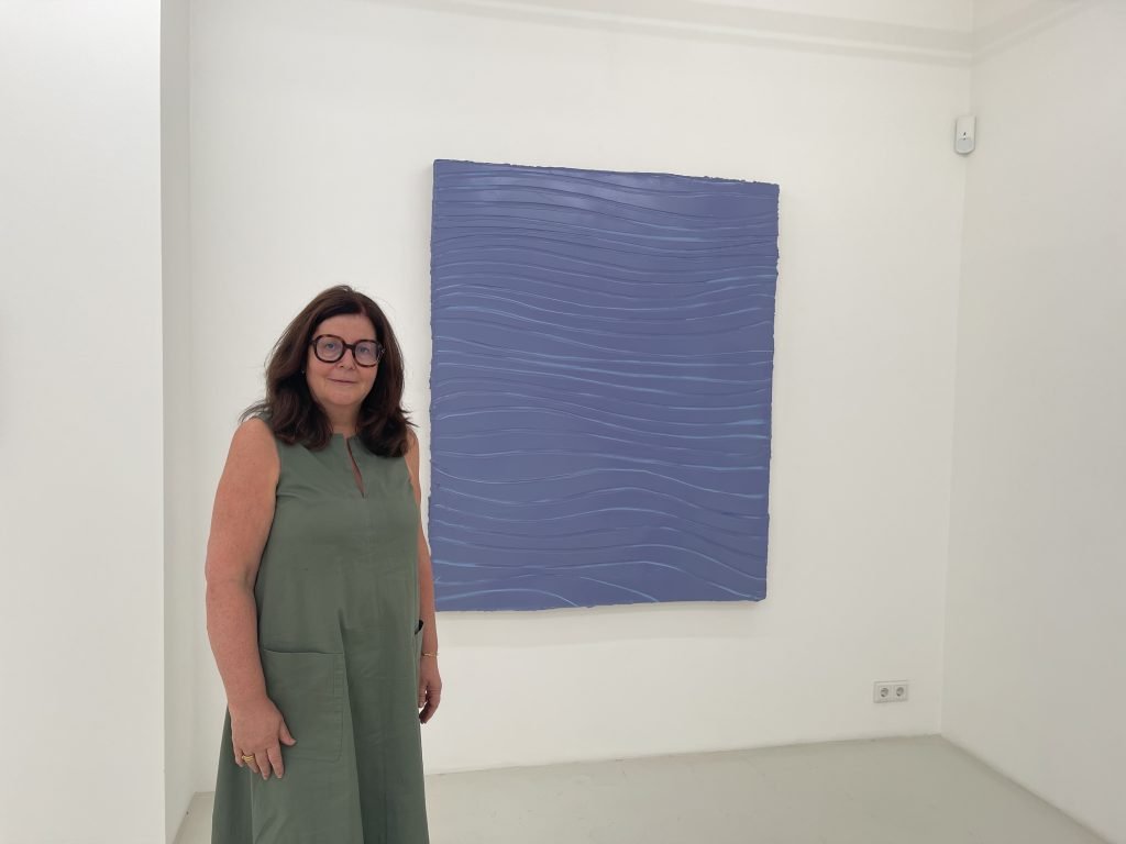 Blau machen ausdrücklich erlaubt: Galeristin Heike Strelow vor Felix Beckers vielschichtiger Malerei. Was zunächst monochrom erscheint, entwickelt beim längeren Hinsehen ein subtiles Spiel aus Linien, Farbtönen und Bewegung. Foto: Edda Rössler