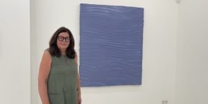 Blau machen ausdrücklich erlaubt: Galeristin Heike Strelow vor Felix Beckers vielschichtiger Malerei. Was zunächst monochrom erscheint, entwickelt beim längeren Hinsehen ein subtiles Spiel aus Linien, Farbtönen und Bewegung. Foto: Edda Rössler